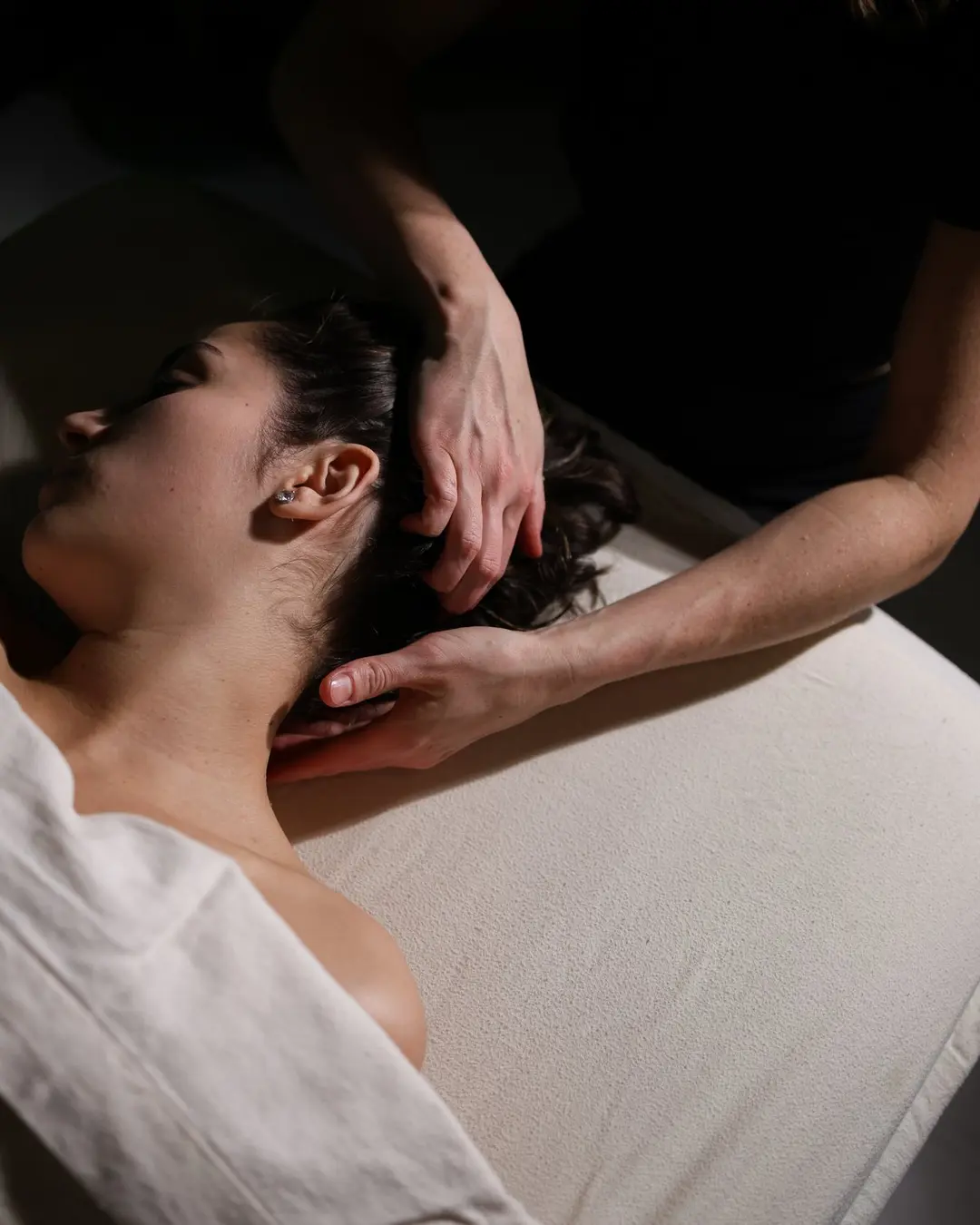 Massage therapist placing hands on a client's shoulders